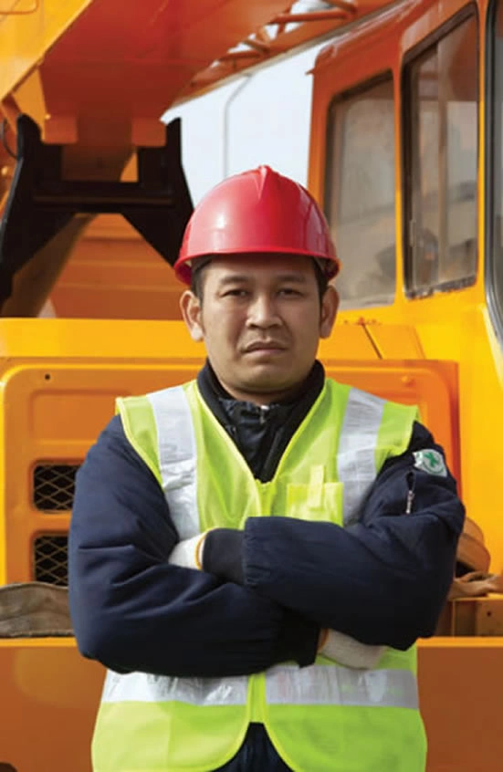 Crane operator wearing safety vest and helmet